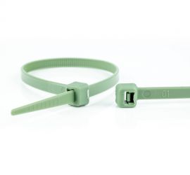 Een groene polypropyleen kabelbinder, chemisch bestendig, naast een uitvergrote sluiting van een andere kabelbinder.
