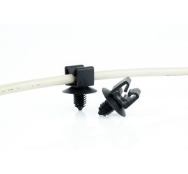 Twee zwarte LFC 6 clips met spreidanker, waarvan één met een kabel door de clip gevoerd, op een witte achtergrond.