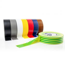 Acht rollen PVC tape naast elkaar in de kleuren zwart, grijs, wit, geel, rood, blauw en bruin, en een geel/groene rol ervoor liggend, op een witte achtergrond.
